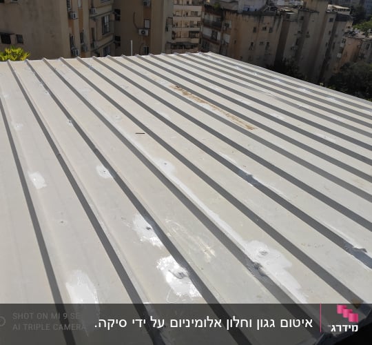 גג מתכת עם איטום לבן בין החריצים